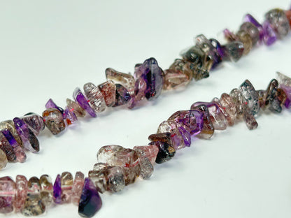 A Super 7 Chip Bead Bracelet with multicolored gemstone chips on a white background
