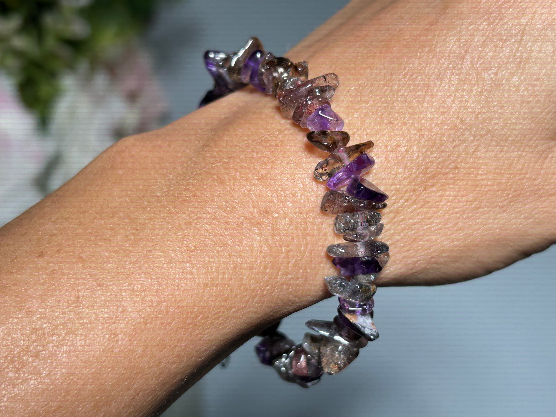 Close up of a wrist wearing a Super 7 Chip Bead Bracelet for meditation and energy work with white background