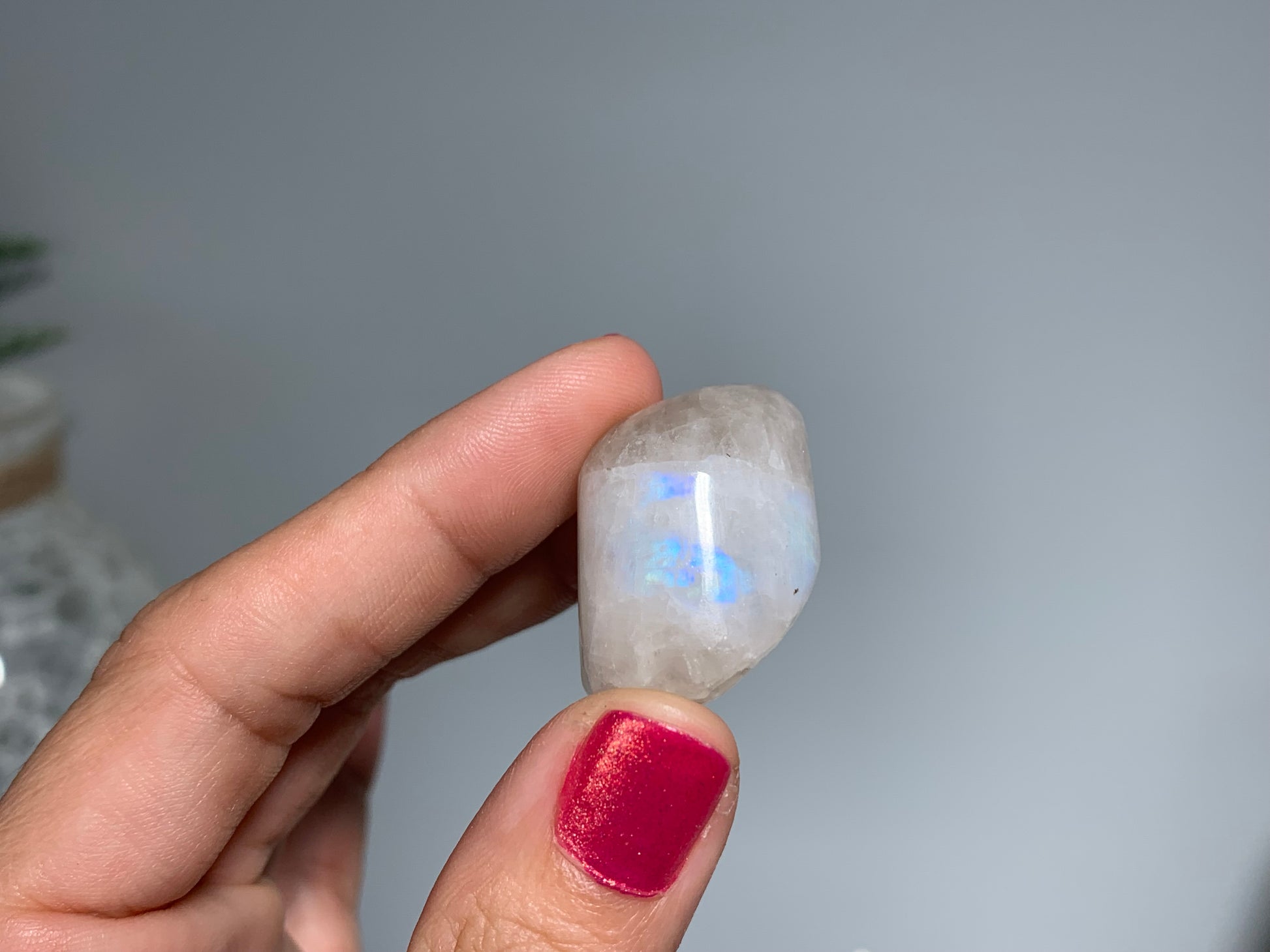 Hand holding Tumbled Moonstone crystal for intuition and feminine energy