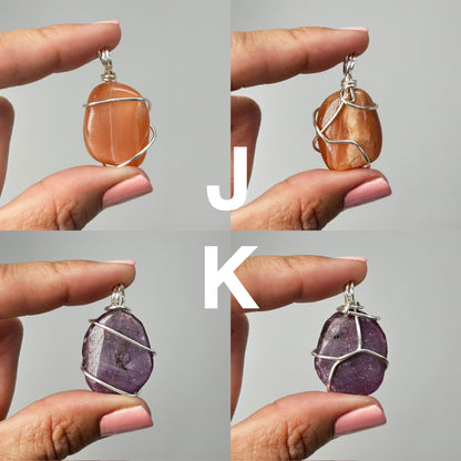 Hands holding Wire Wrapped Crystal Pendants with white background.