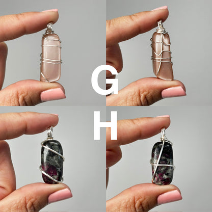 Hands holding Wire Wrapped Crystal Pendants for meditation and energy work with white background.