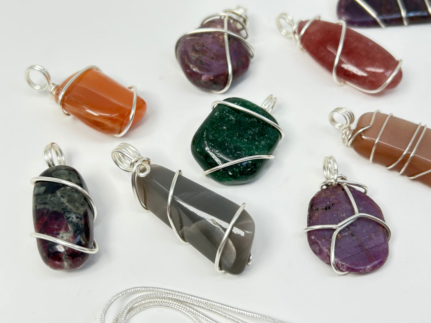 Wire Wrapped Crystal Pendants for natural grounding on table with white background.