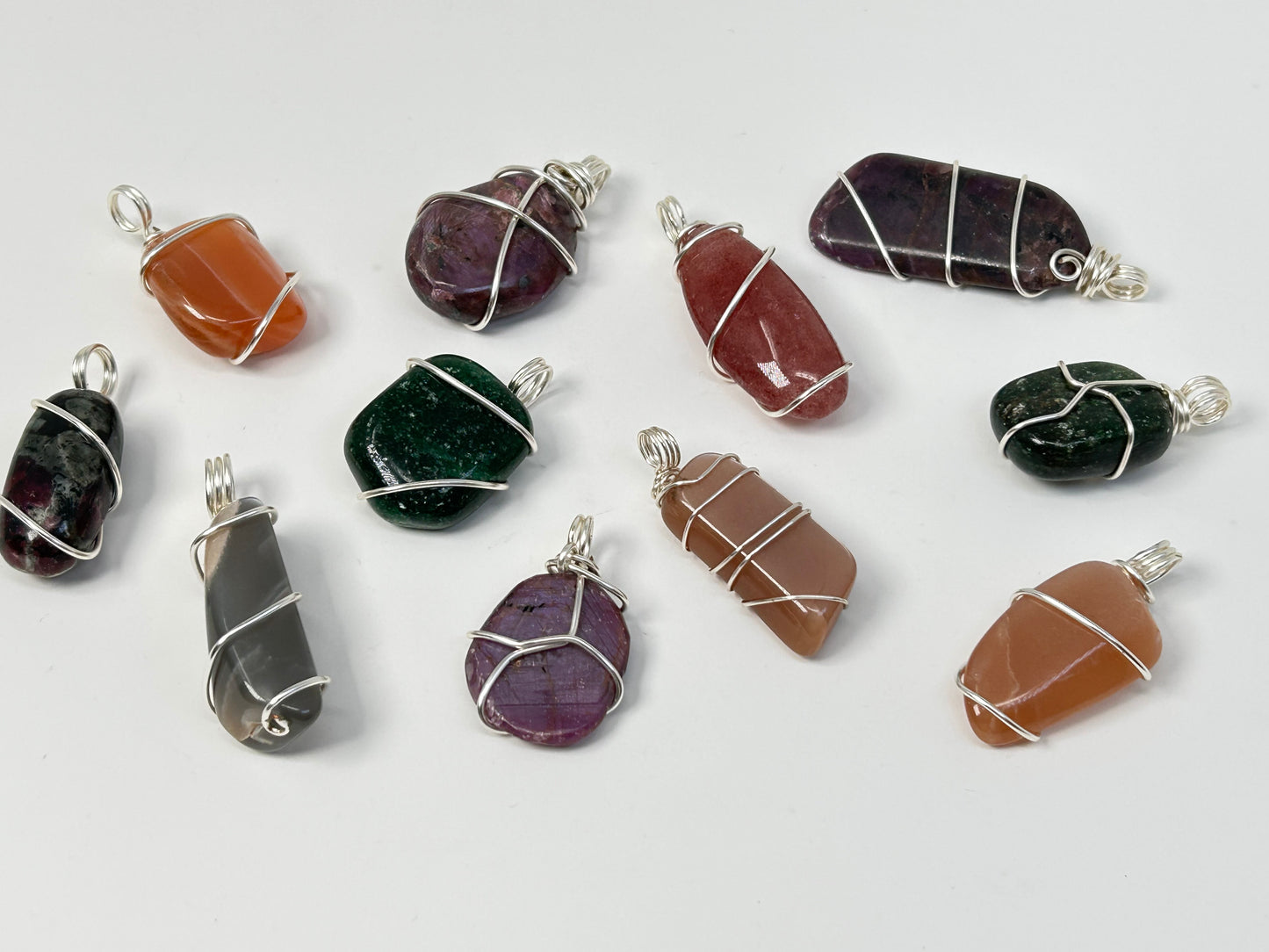 Wire Wrapped Crystal Pendants on table top with white background