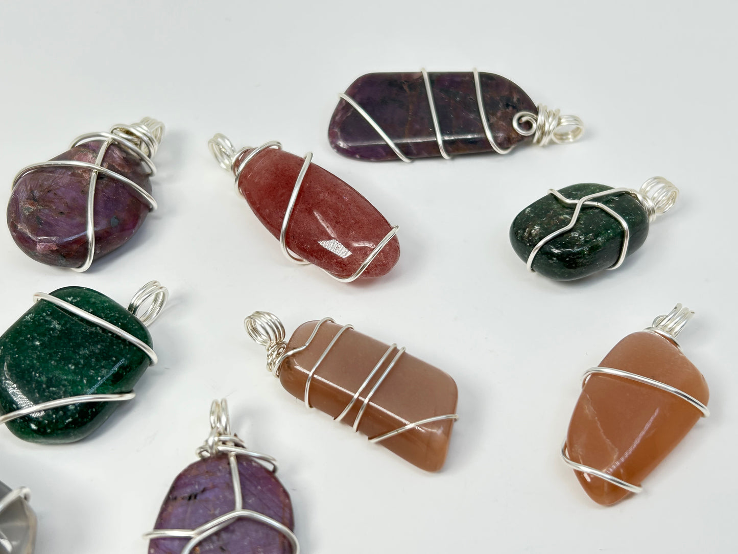 Wire Wrapped Crystal Pendants on table with white background.
