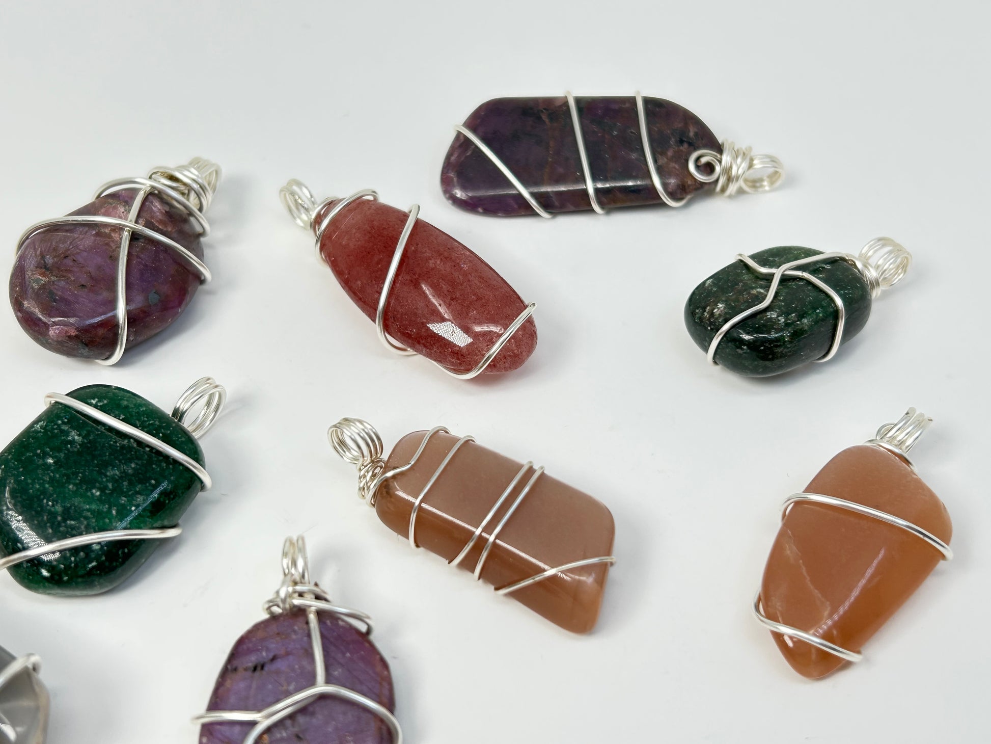 Wire Wrapped Crystal Pendants on table with white background.