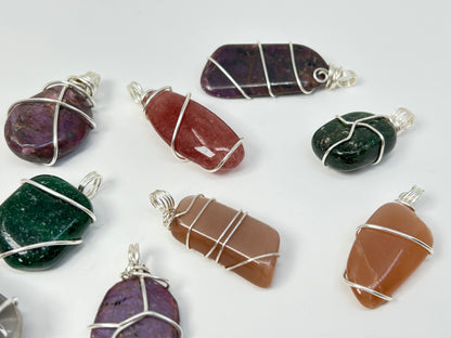 Wire Wrapped Crystal Pendants on table with white background.