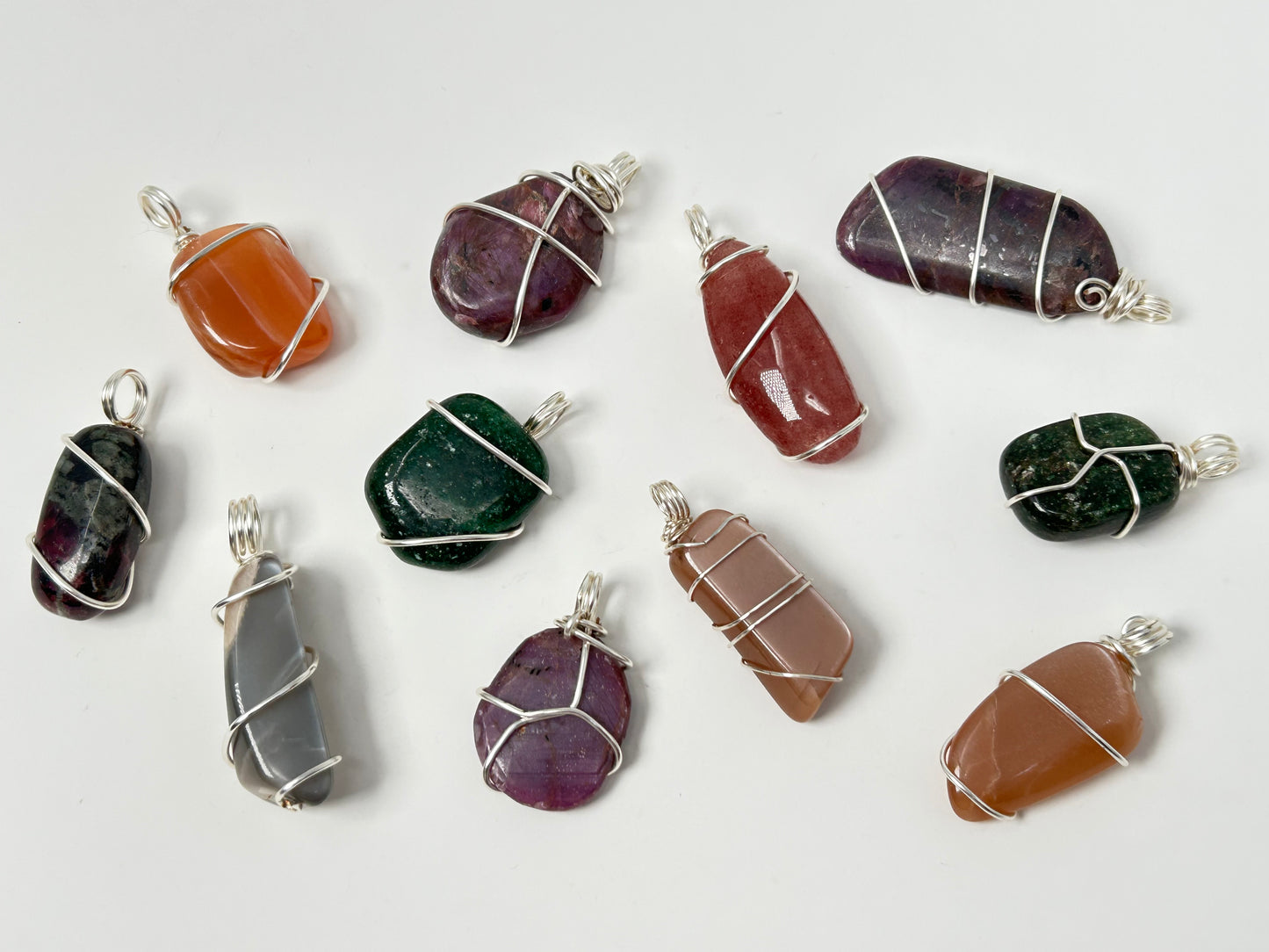 Collection of various Wire Wrapped Crystal Pendants for natural grounding on a white background