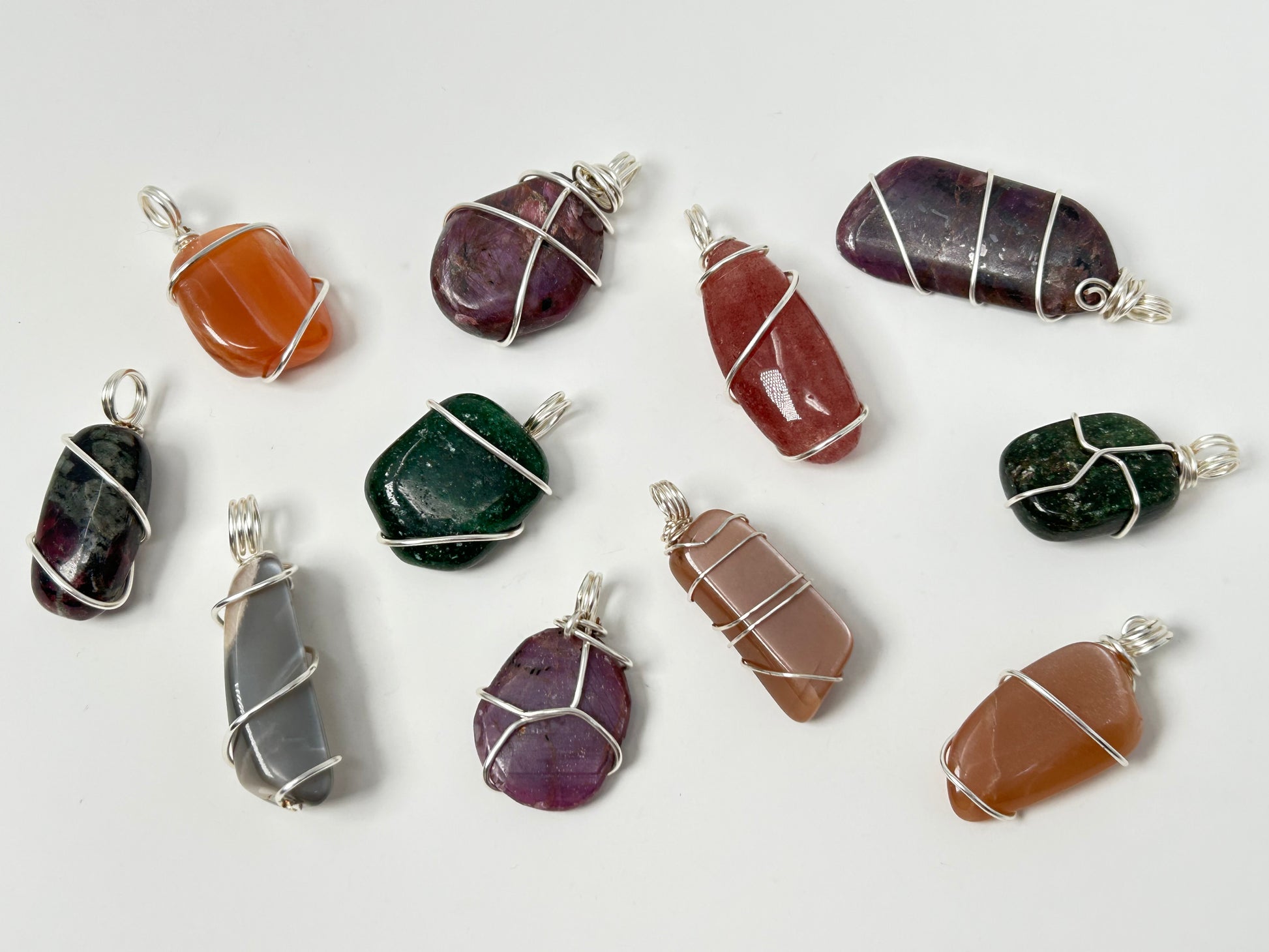 Collection of various Wire Wrapped Crystal Pendants for natural grounding on a white background