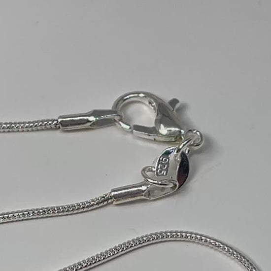 Wire Wrapped Crystal Pendants for natural grounding and silver necklace chain on table with white background.