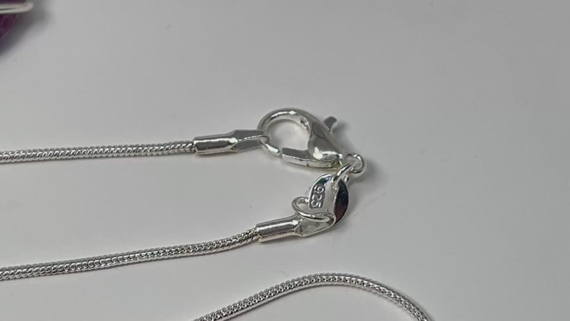 Wire Wrapped Crystal Pendants for natural grounding and silver necklace chain on table with white background.