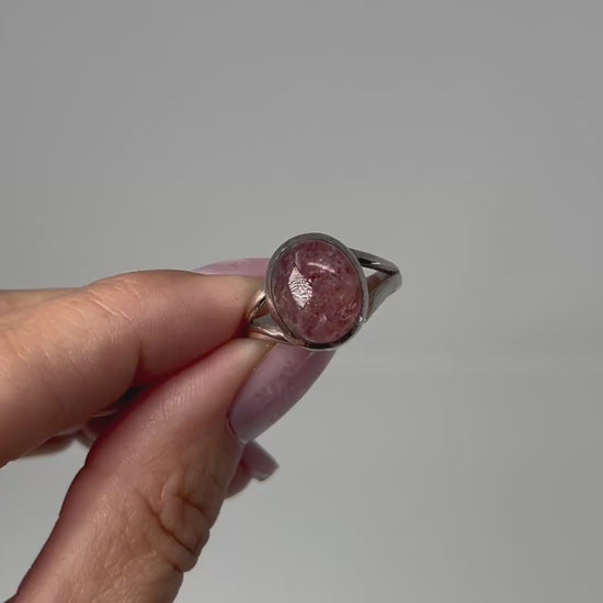 Hand holding Cherry Tanzurine Sterling Silver Ring with white background.