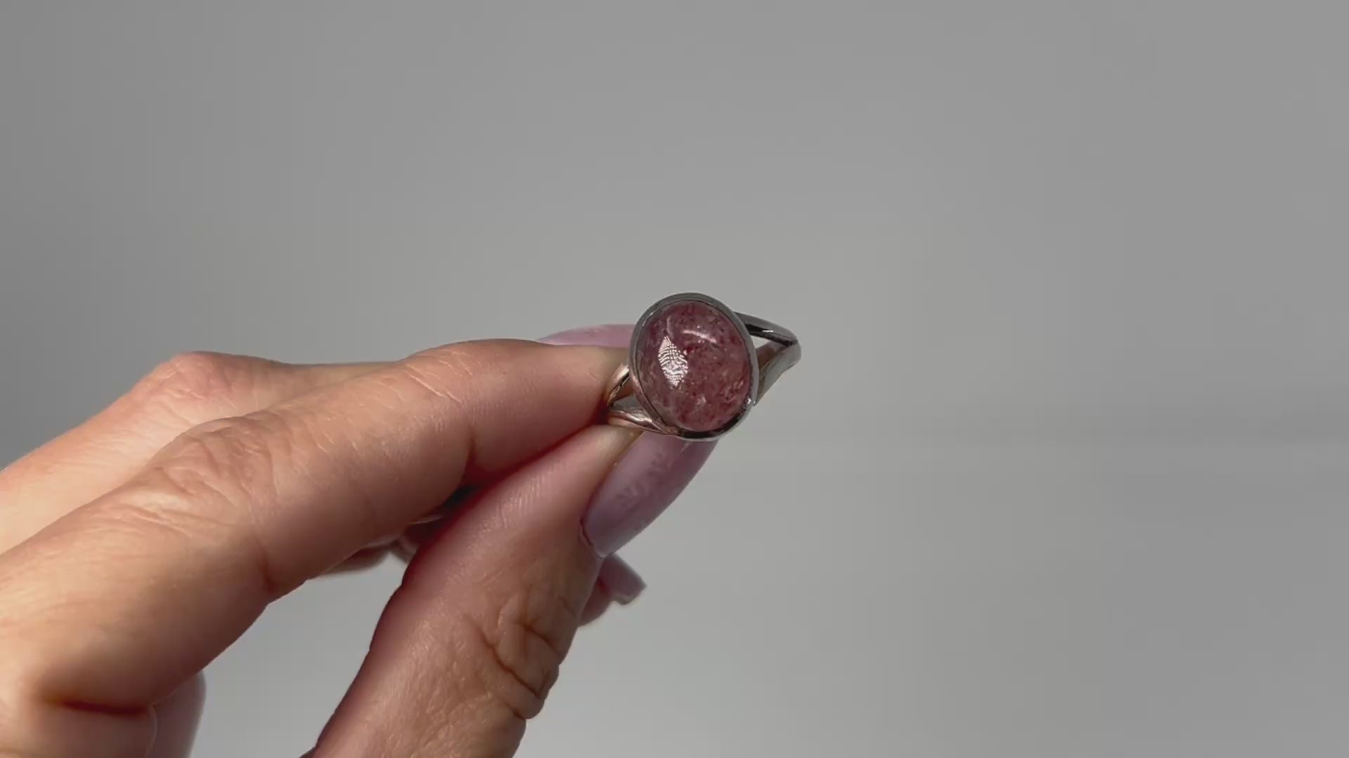 Hand holding Cherry Tanzurine Sterling Silver Ring with white background.